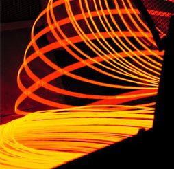 Glowing hot steel rods coiling at the rolling mill